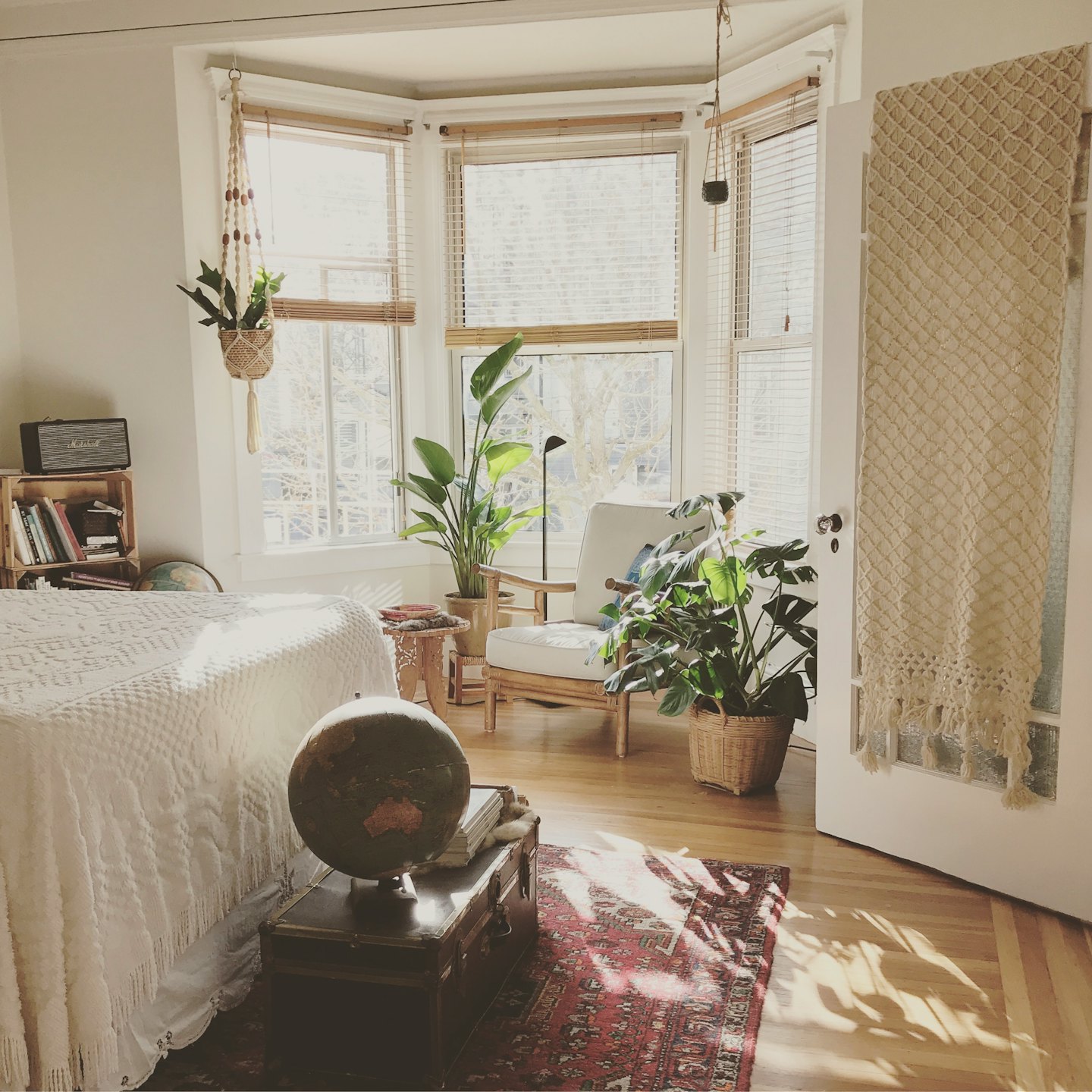 Sonnenlicht fällt in ein gemütliches Schlafzimmer mit Pflanzen und einem Globus.