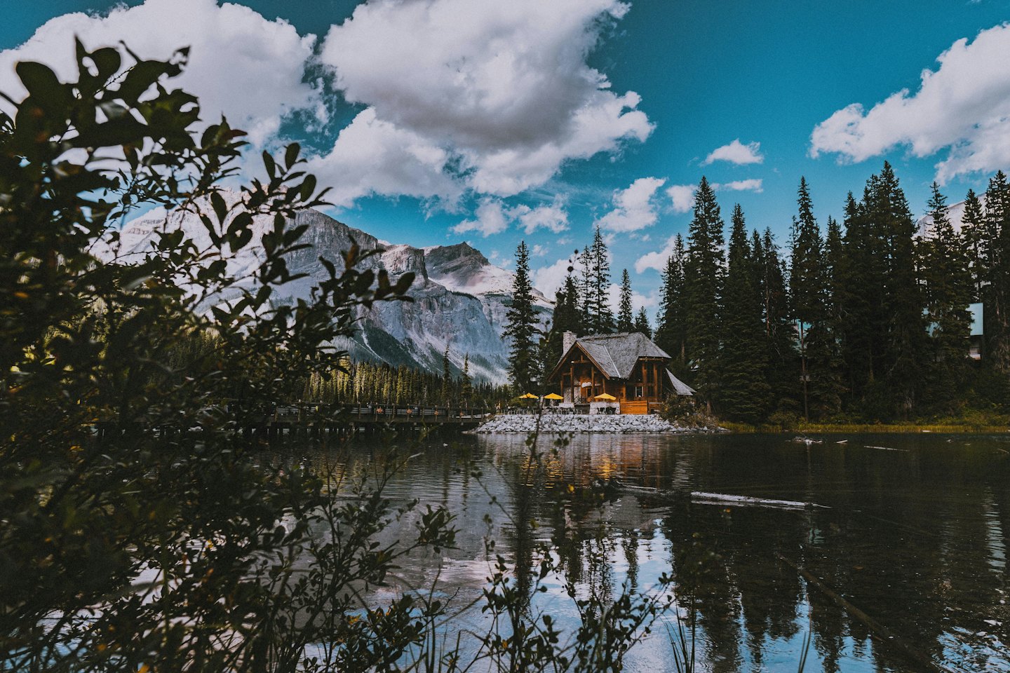 Eine rustikale Holzhütte steht am felsigen Ufer eines Sees.